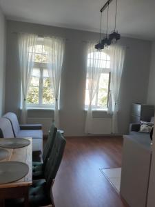 salon ze stołem i 2 oknami w obiekcie APARTAMENT KOSZARY na NOVO w mieście Mrągowo