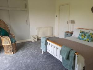 a bedroom with a large bed and a chair at The Fold - 5 mins to Lytham St Annes - Ribby Hall Village 