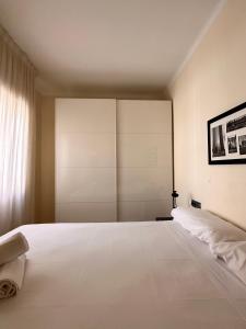 een slaapkamer met een groot wit bed en een raam bij Gracia Barcelona Apartment in Barcelona