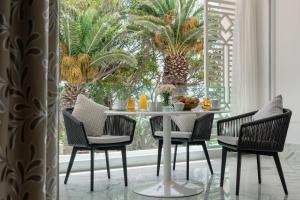Marchica Lagoon Resort في الناظور: غرفة طعام مع طاولة وكراسي وأشجار نخيل