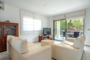 salon z 2 białymi krzesłami i telewizorem w obiekcie Villa JAITIT beach Son Serra w mieście Son Serra de Marina