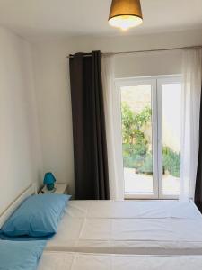 - une chambre avec un grand lit et une fenêtre dans l'établissement Villa Kata, à Preko