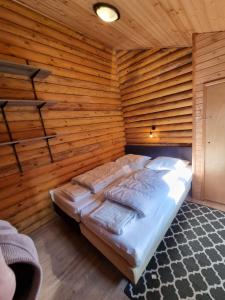 ein Schlafzimmer mit einem Bett in einer Holzwand in der Unterkunft Finse Woning op Camping De Tulpenweide in Breezand