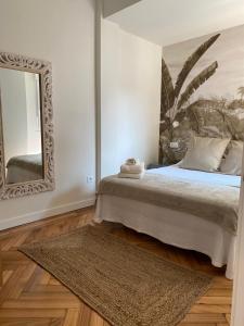 a bedroom with a bed with a mirror and a rug at SUITE HAUS Catedral in Santander