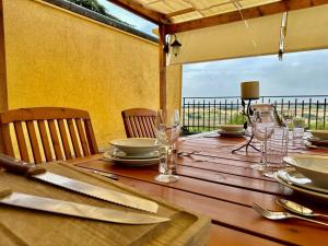 una mesa de madera con platos y vasos. en Fantastica terrazza con solarium e infernot by Revenue House, en Vignale