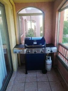 a blue grill sitting on a counter next to a window at Condominio Ilimay Las Cruces in Las Cruces