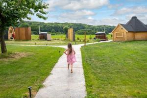 FarbusLogements insolites à la ferme - Yourte, Kota ou Pod的穿着粉红色衣服的小女孩在人行道上走下