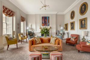 a living room with an orange couch and chairs at The Royal Crescent Hotel & Spa in Bath
