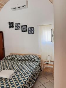 ポリニャーノ・ア・マーレにあるDimora dei Pellegrini 8のベッドルーム1室(ベッド1台付)が備わります。壁には絵画が飾られています。