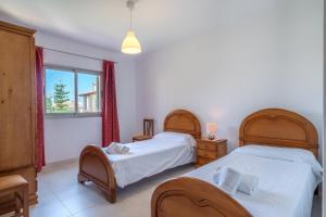 sypialnia z 2 łóżkami i oknem w obiekcie Villa JAITIT beach Son Serra w mieście Son Serra de Marina