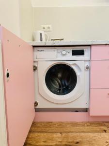 pralka i suszarka w różowej kuchni w obiekcie Apartamenty Kamienica Gwiazda w mieście Krynica Zdrój