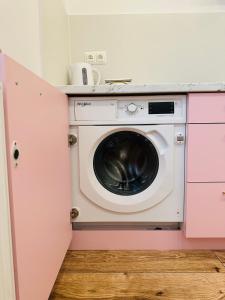 pralka i suszarka w różowej kuchni w obiekcie Apartamenty Kamienica Gwiazda - Centrum miasta, parking gratis w mieście Krynica Zdrój