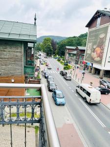 ruchliwa ulica miejska z samochodami zaparkowanymi na drodze w obiekcie Apartamenty Kamienica Gwiazda w mieście Krynica Zdrój