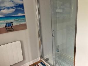 a bathroom with a shower with a picture of the beach at Seaview bungalow in Hornsea