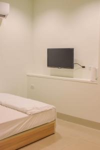 una camera con letto e TV a schermo piatto a parete di TETE Homestay a Xiaoliuqiu