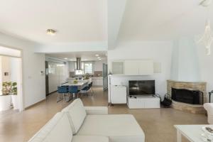 a living room with a white couch and a kitchen at Protaras Sunrise Zen Seafront Villa in Protaras