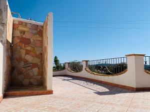 uma varanda com uma parede de pedra e uma cerca em Casa Vacanza Serena em SantʼAnna Arresi