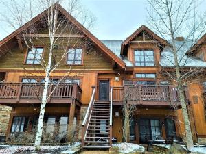 a large wooden house with a staircase in front of it at EDM 1500-2/Your Mountain Oasis in Mont-Tremblant