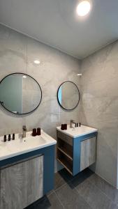 a bathroom with two sinks and two mirrors at Hospitality Hotel in Xiaoliuqiu