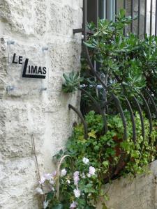 una señal en el lado de un edificio con plantas en Le Limas, en Aviñón