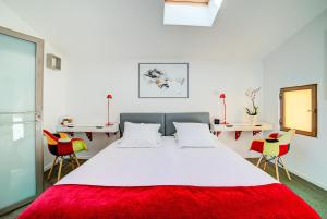 a bedroom with a large white bed with chairs at Le Limas in Avignon +15 photos