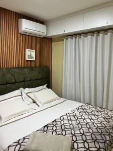 - une chambre avec un grand lit et un couvre-lit blanc dans l'établissement Apartamento aconchegante., à Petrolina