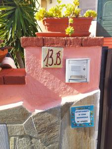 una pared de ladrillo con una señal de bbb en ella en Appartamento in zona residenziale en Orosei