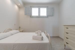 Case del Pescatore في مارينا بورتو: غرفة نوم بيضاء مع سرير عليه مناشف