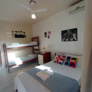 een slaapkamer met 2 bedden en een stapelbed bij Pousada do Rock in Arraial d'Ajuda