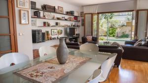 uma sala de estar com uma mesa de vidro com um vaso sobre ela em Villa Palma 3 em Palma de Maiorca