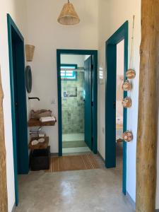 a bathroom with blue doors and a walk in shower at Vila Aratu Corumbau in Corumbau