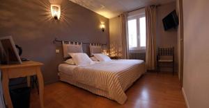 a bedroom with a large white bed with a window at Hôtel Le Boïate in Arès