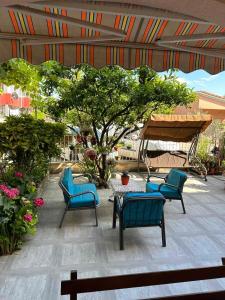 un patio con sillas, una mesa y un árbol en Guest House Andrea, en Budva