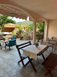 un patio con mesa, sillas y sombrilla en Guest House Andrea, en Budva