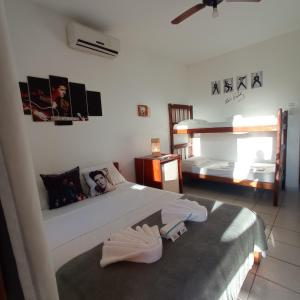 een slaapkamer met een bed en 2 stapelbedden bij Pousada do Rock in Arraial d'Ajuda