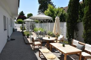 a patio with tables and chairs and an umbrella at Landhaus Rust in Rust