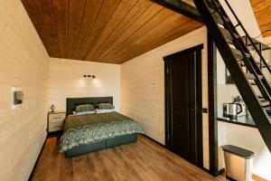 1 dormitorio con cama y techo de madera en Tindioru Valley Resort, en Rõuge