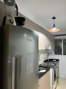 Il comprend une cuisine équipée d'un réfrigérateur en acier inoxydable et d'une cuisinière. dans l'établissement Apartamento aconchegante., à Petrolina