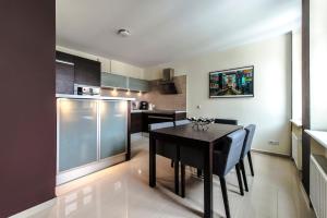 cocina con mesa negra y sillas en una habitación en Hello Apartments River View 5 bedrooms VERY BIG 100 m2 en Gdansk