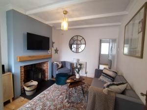 a living room with a couch and a fireplace at Martha's cottage by the sea in Gorleston-on-Sea