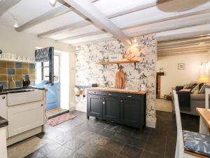 een keuken en een woonkamer met een fornuis en een aanrecht bij Bumblebee Cottage in Fakenham