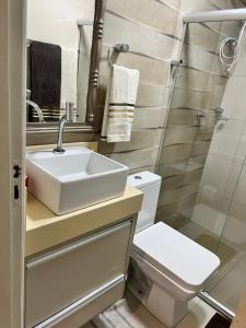 La salle de bains est pourvue d'un lavabo, de toilettes et d'une douche. dans l'établissement Apartamento aconchegante., à Petrolina