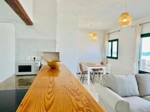 a kitchen and living room with a wooden table at Famara Frontsea house in Famara