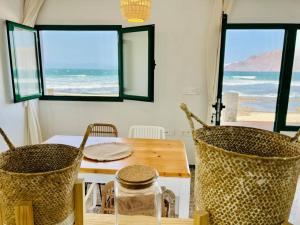 a dining room with a table and chairs and the ocean at Famara Frontsea house in Famara