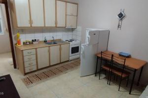 a small kitchen with a white refrigerator and a table at Δ2 in Dhidhimótikhon