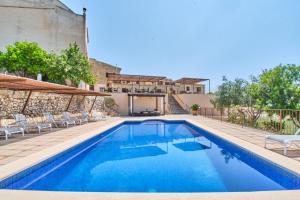 - une piscine d'eau bleue dans une maison dans l'établissement Casa de Can Riera con Piscina Comunitaria, à Moscari