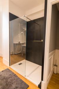 - une porte de douche en verre dans une chambre avec un sol dans l'établissement Château du Rondon, à Olivet
