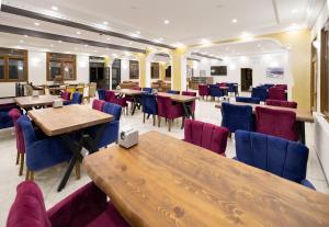 a restaurant with wooden tables and blue chairs at Avulot Mountain Resort Hotel in Trabzon