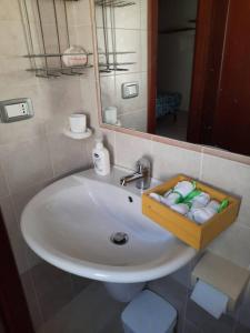 a bathroom sink with a wooden tray of towels at Stylish Loft Trivano Cagliari 2 beds/2 bath in Cagliari