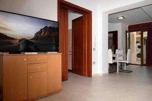 een woonkamer met een grote flatscreen-tv bij Stylish Loft Trivano Cagliari 2 beds/2 bath in Cagliari